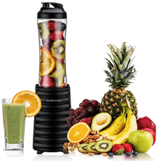 La Reveuse Portable Blender filled with fruits and a glass filled with green smoothie